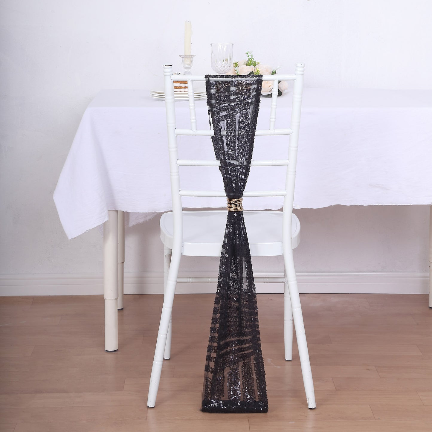 Black geometric diamond glitz sequin chair sash on a white chair.