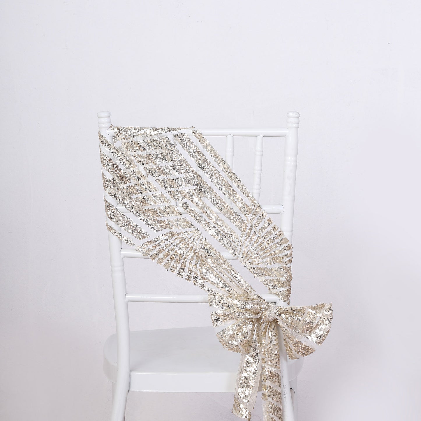 Champagne geometric diamond glitz sequin chair sash on a white chair.