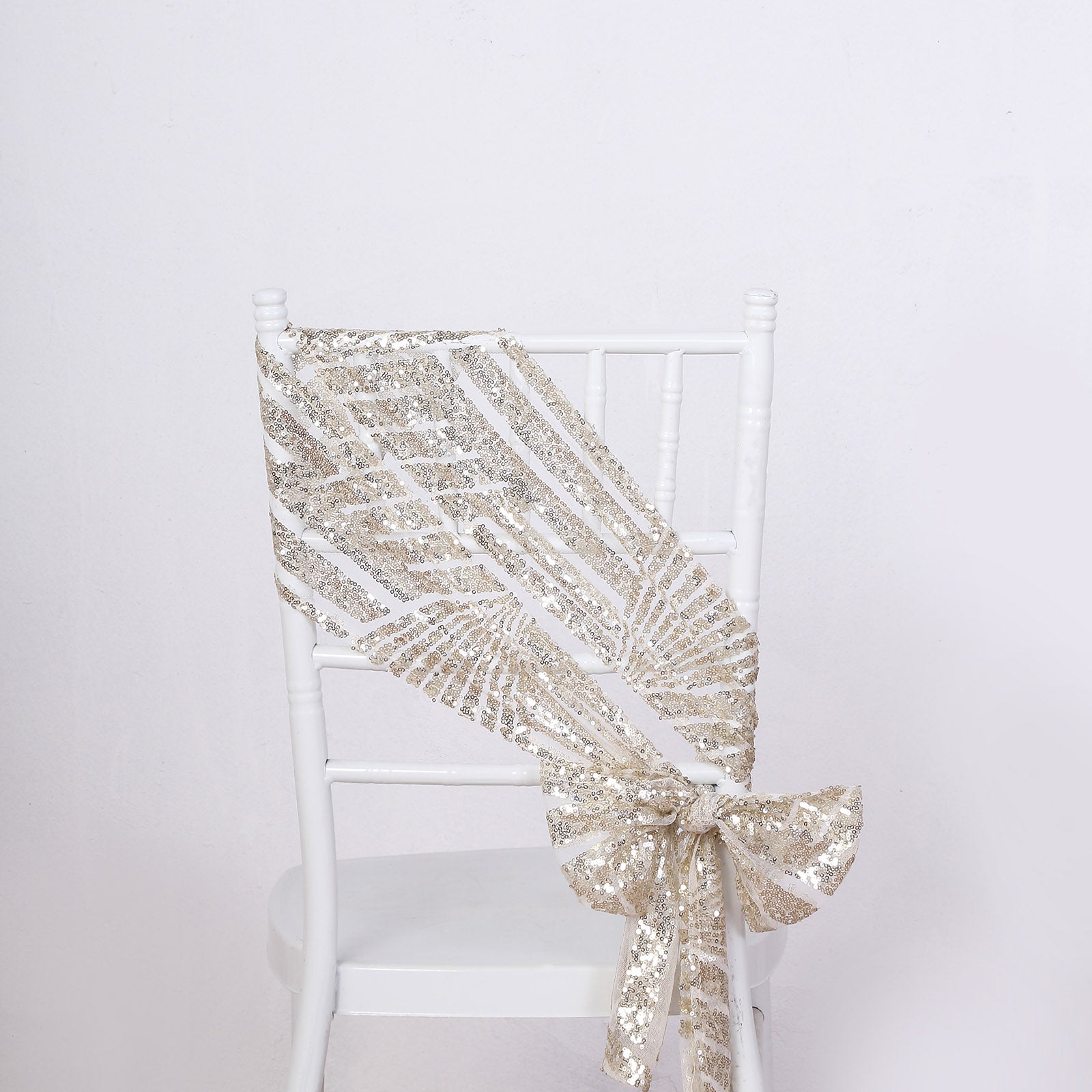 Champagne geometric diamond glitz sequin chair sash on a white chair.