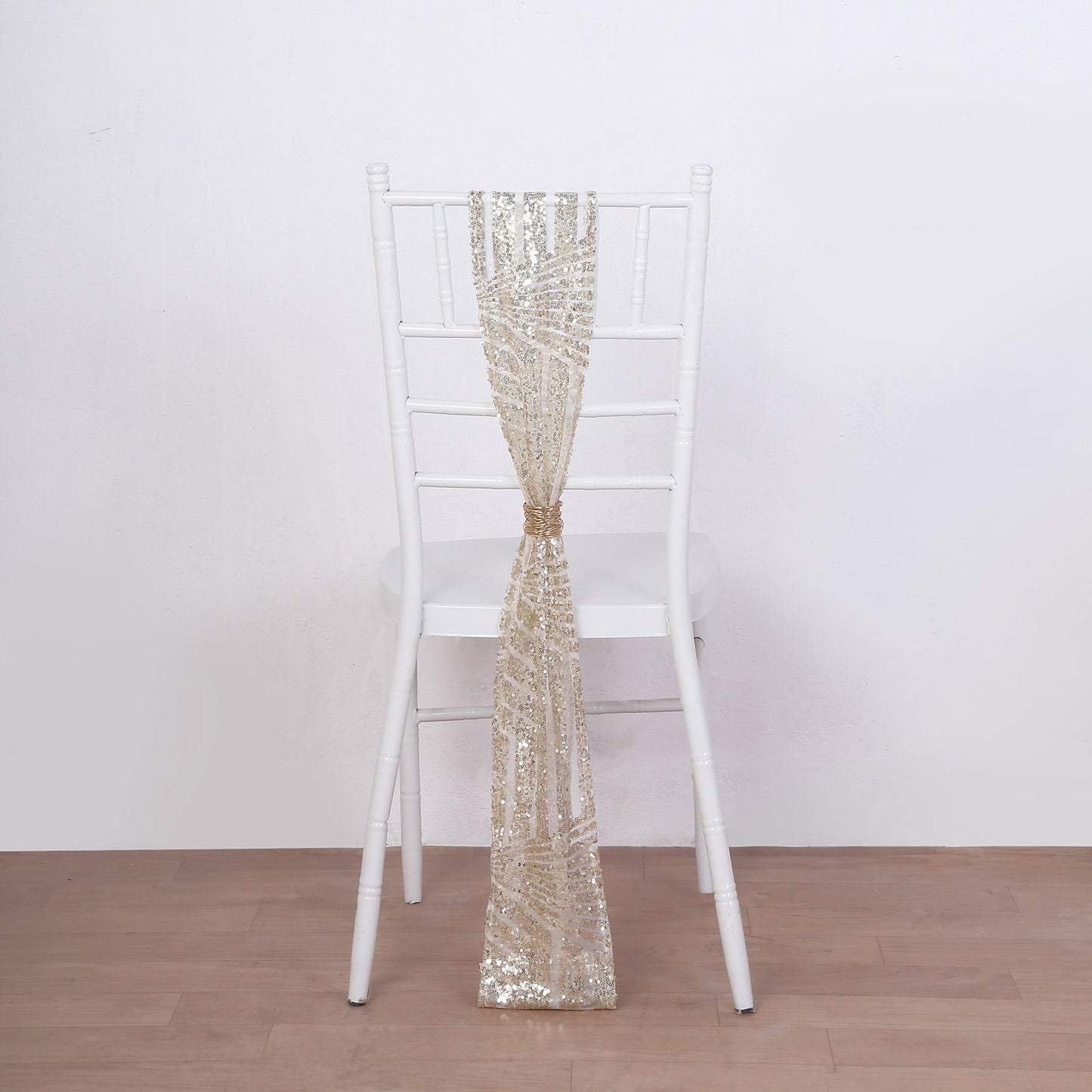 Champagne geometric diamond glitz sequin chair sash on a white chair.