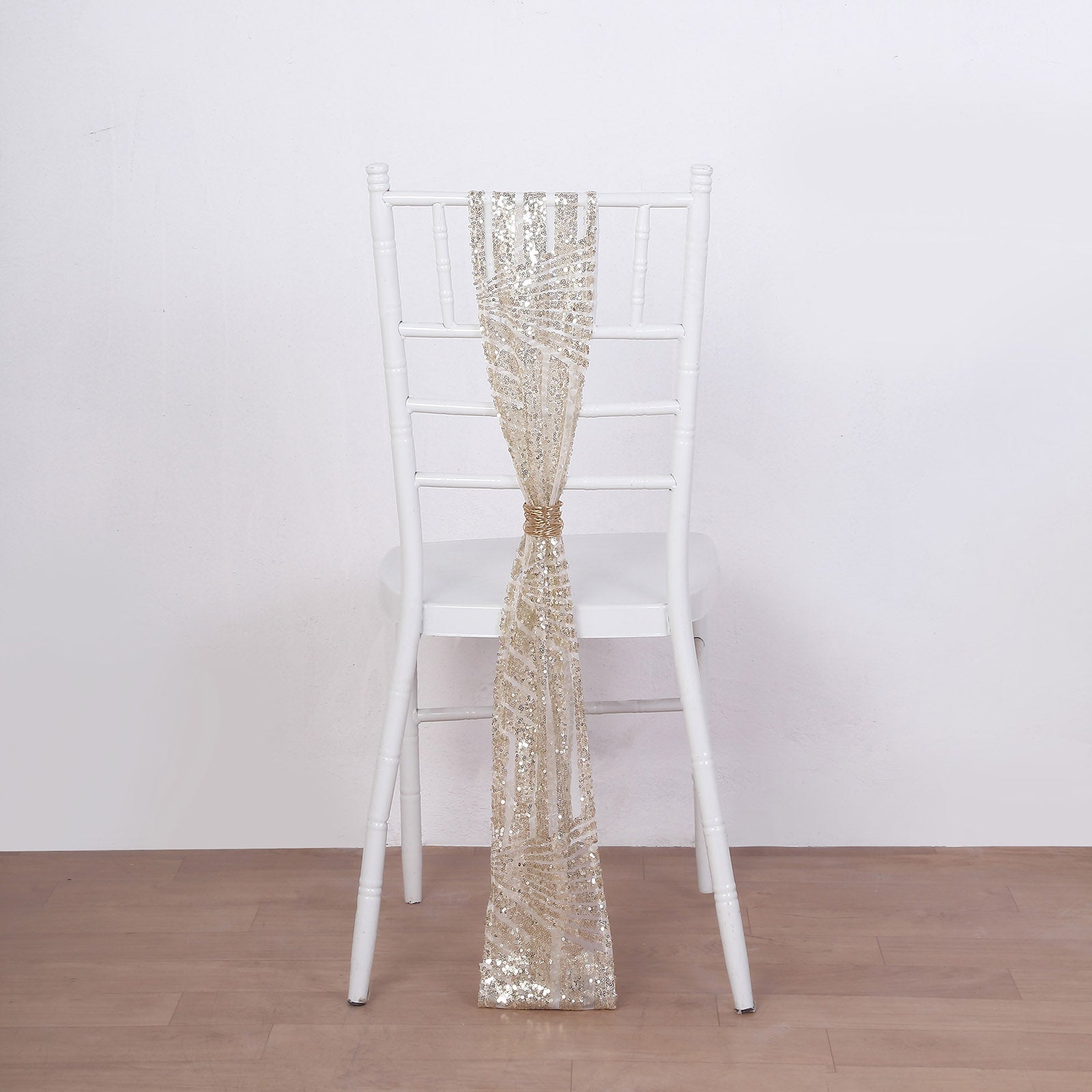 Champagne geometric diamond glitz sequin chair sash on a white chair.