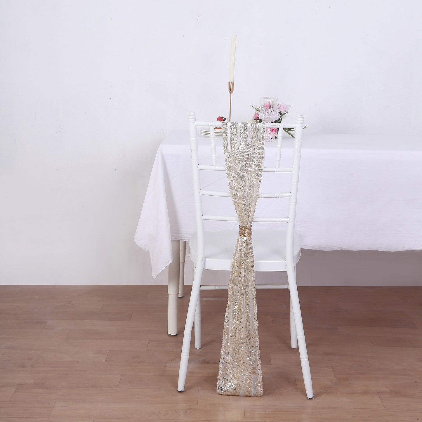 Champagne geometric diamond glitz sequin chair sash on a white chair.