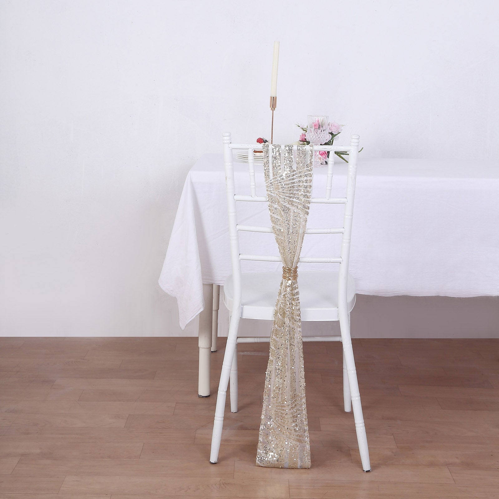 Champagne geometric diamond glitz sequin chair sash on a white chair.