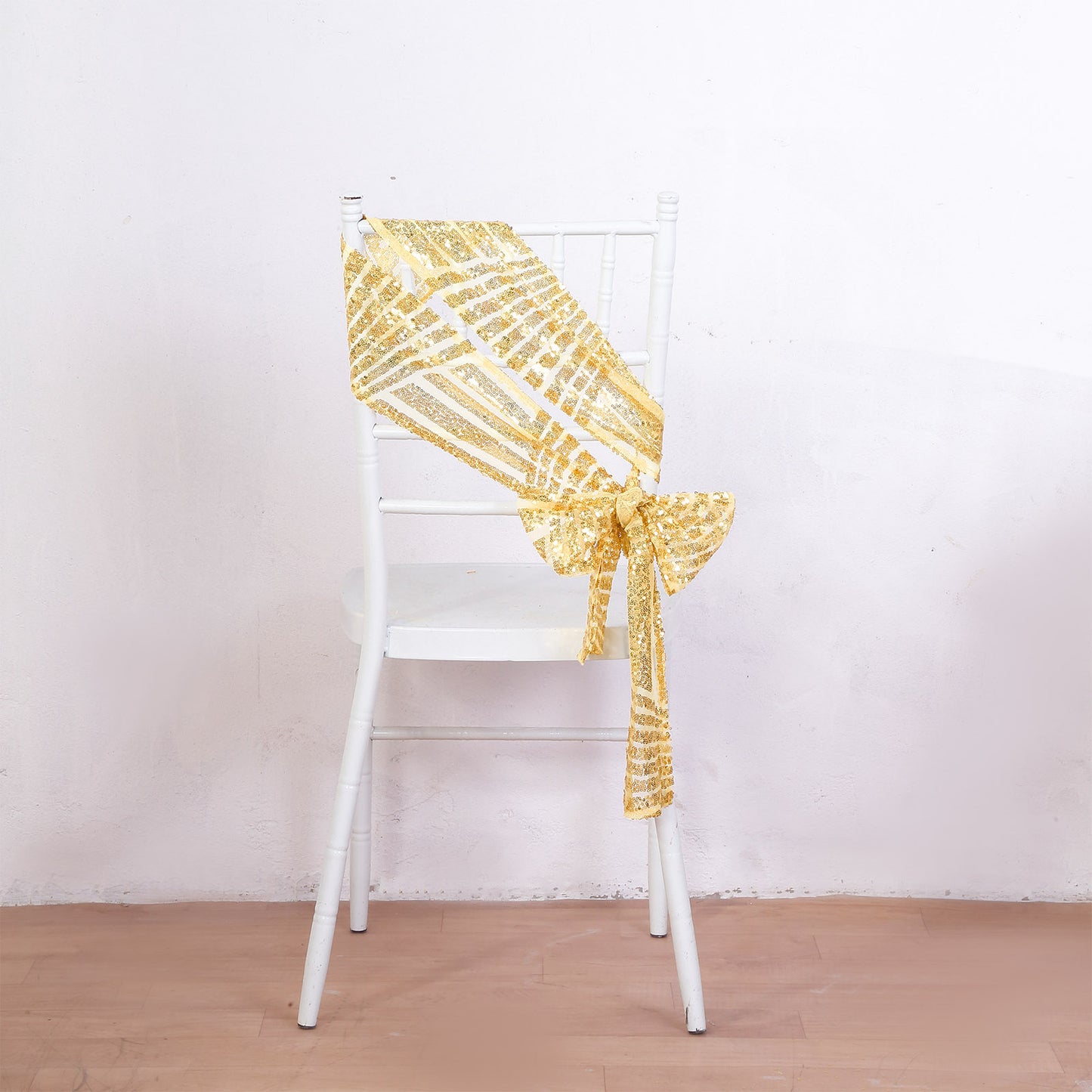 Gold sequin chair sash with geometric diamond pattern on a white chair.