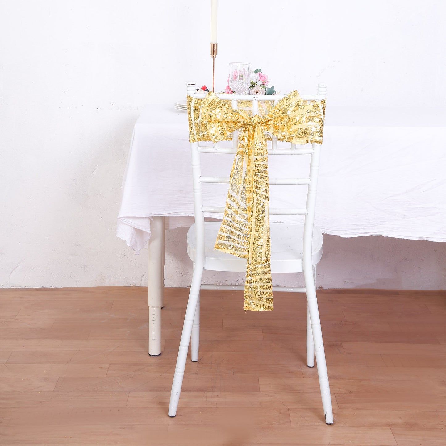 Gold geometric diamond glitz sequin chair sash on a white chair.