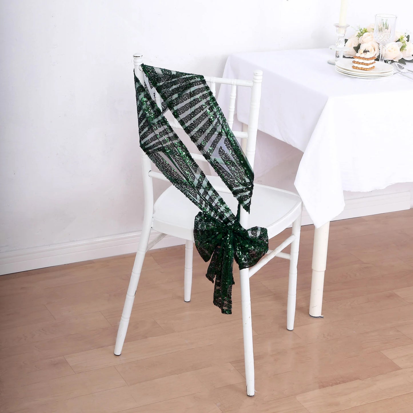 Emerald green geometric diamond glitz sequin chair sash on a white chair.