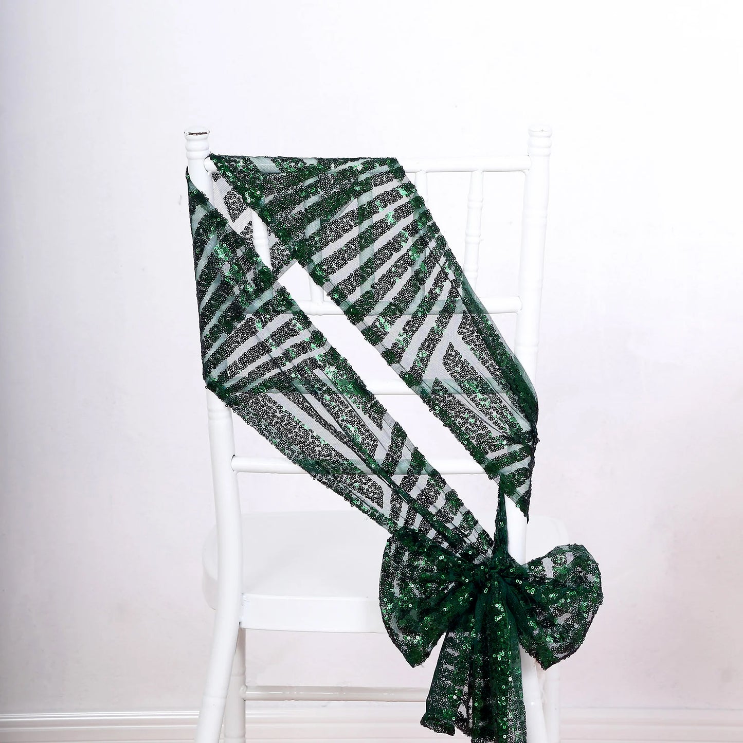 Emerald green geometric diamond glitz sequin chair sash on a white chair.