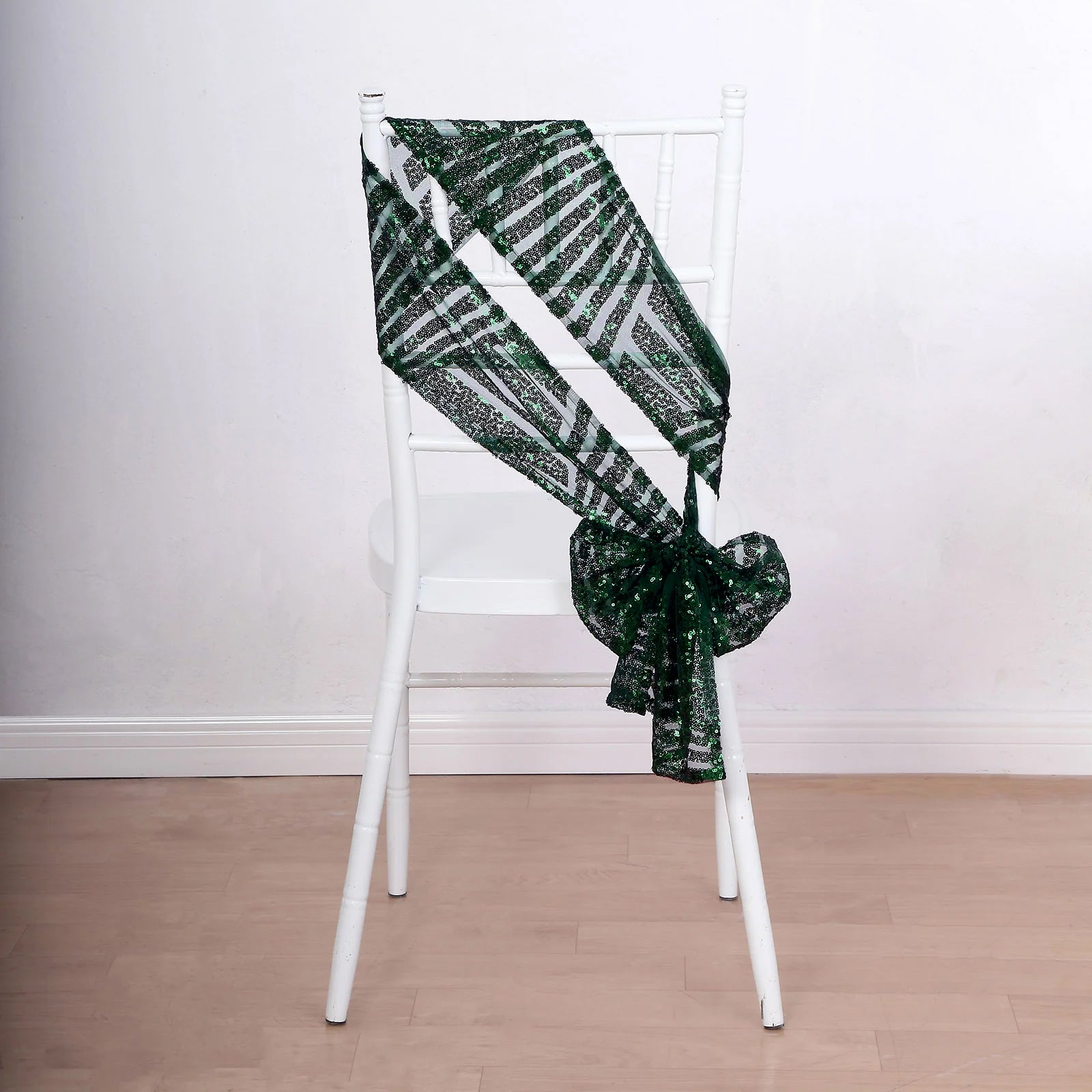 Emerald green geometric diamond glitz sequin chair sash on a white chair.