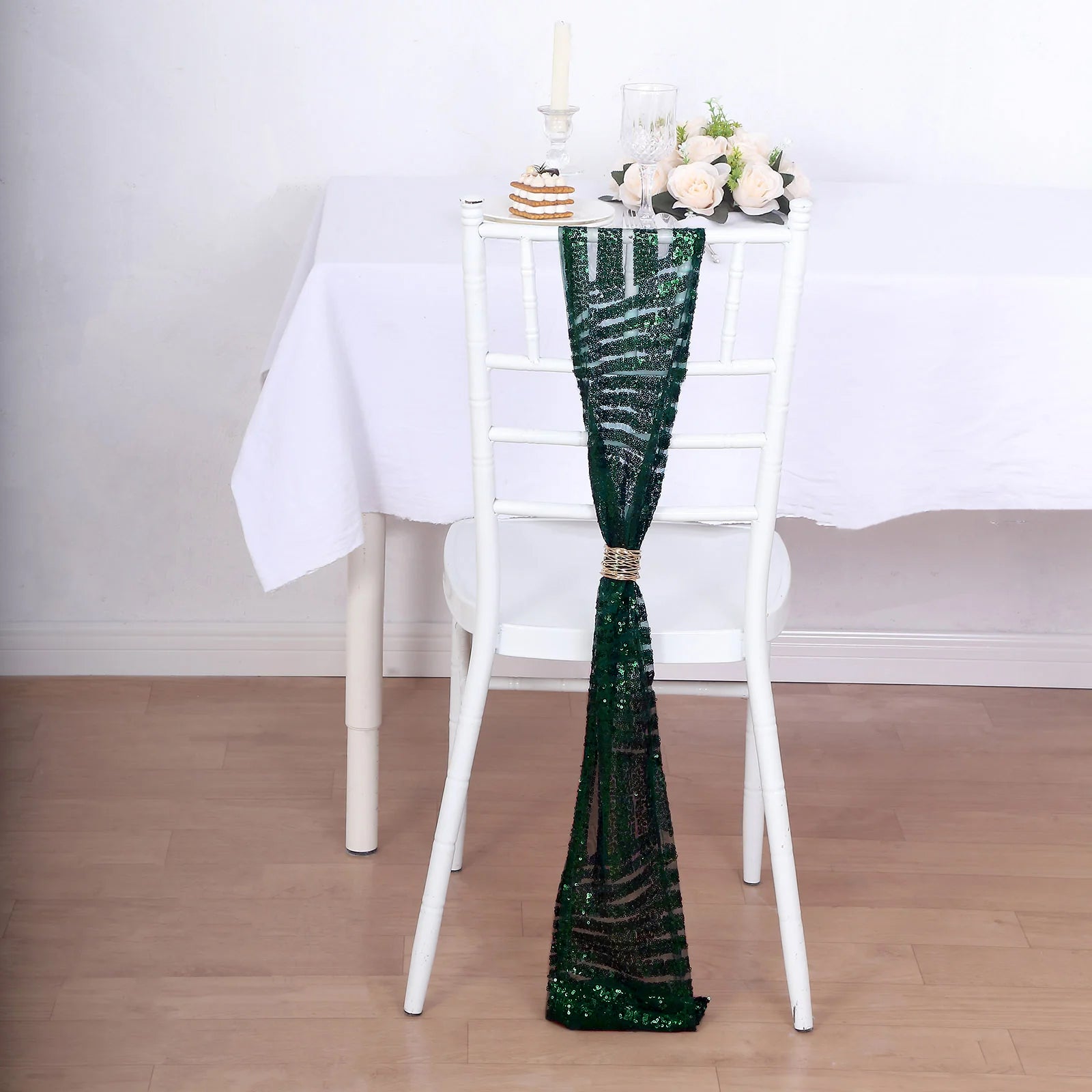 Emerald green geometric diamond sequin chair sash draped on a white chair.