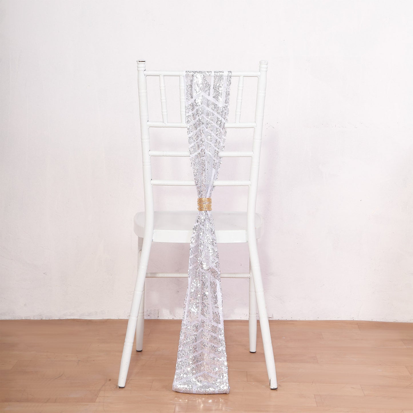 Silver geometric diamond glitz sequin chair sash on a white chair.