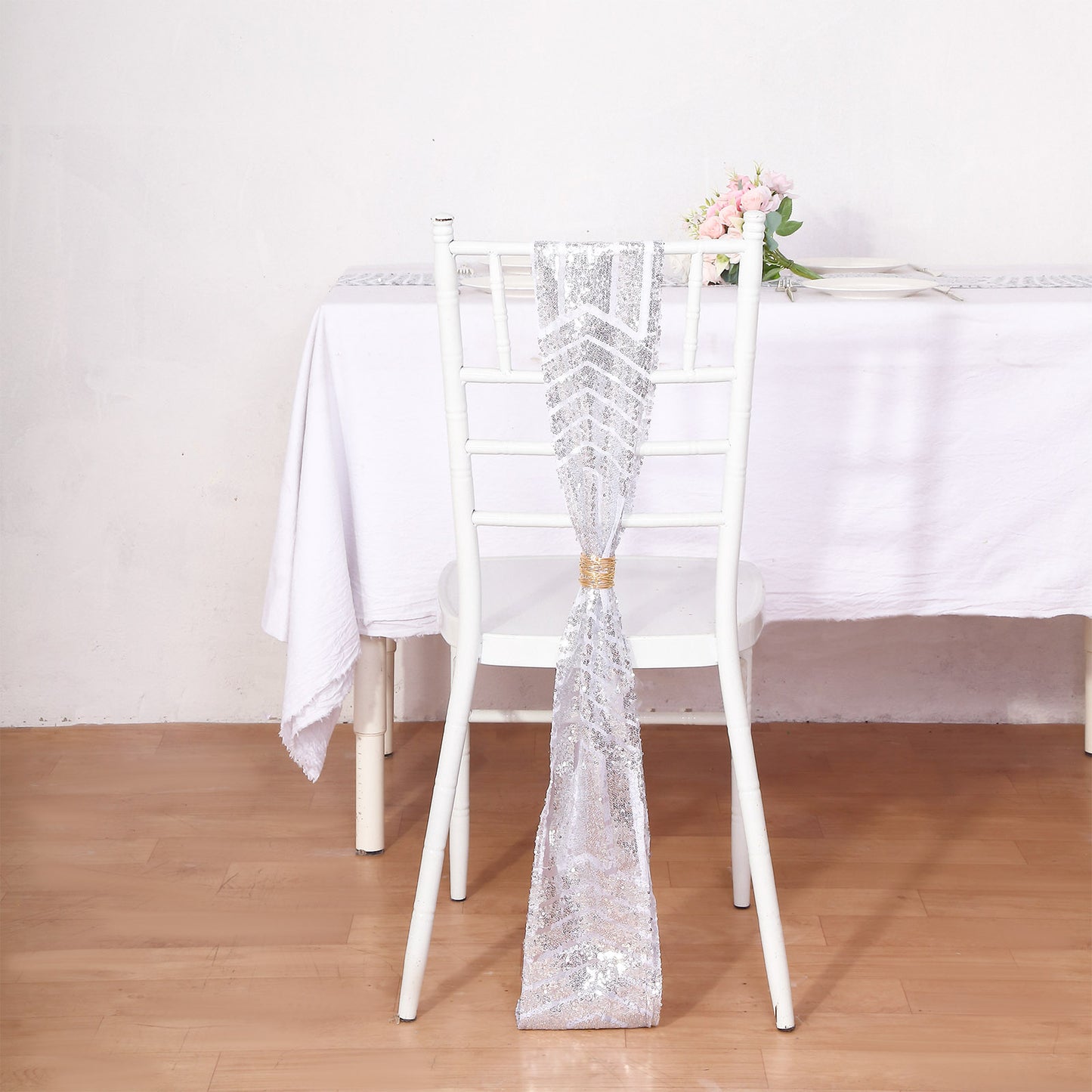 Silver geometric diamond glitz sequin chair sash on a white chair.