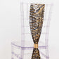 Black and gold wave embroidered sequin chair sash on clear chair.