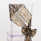 Black and gold wave embroidered sequin chair sash on a clear chair.