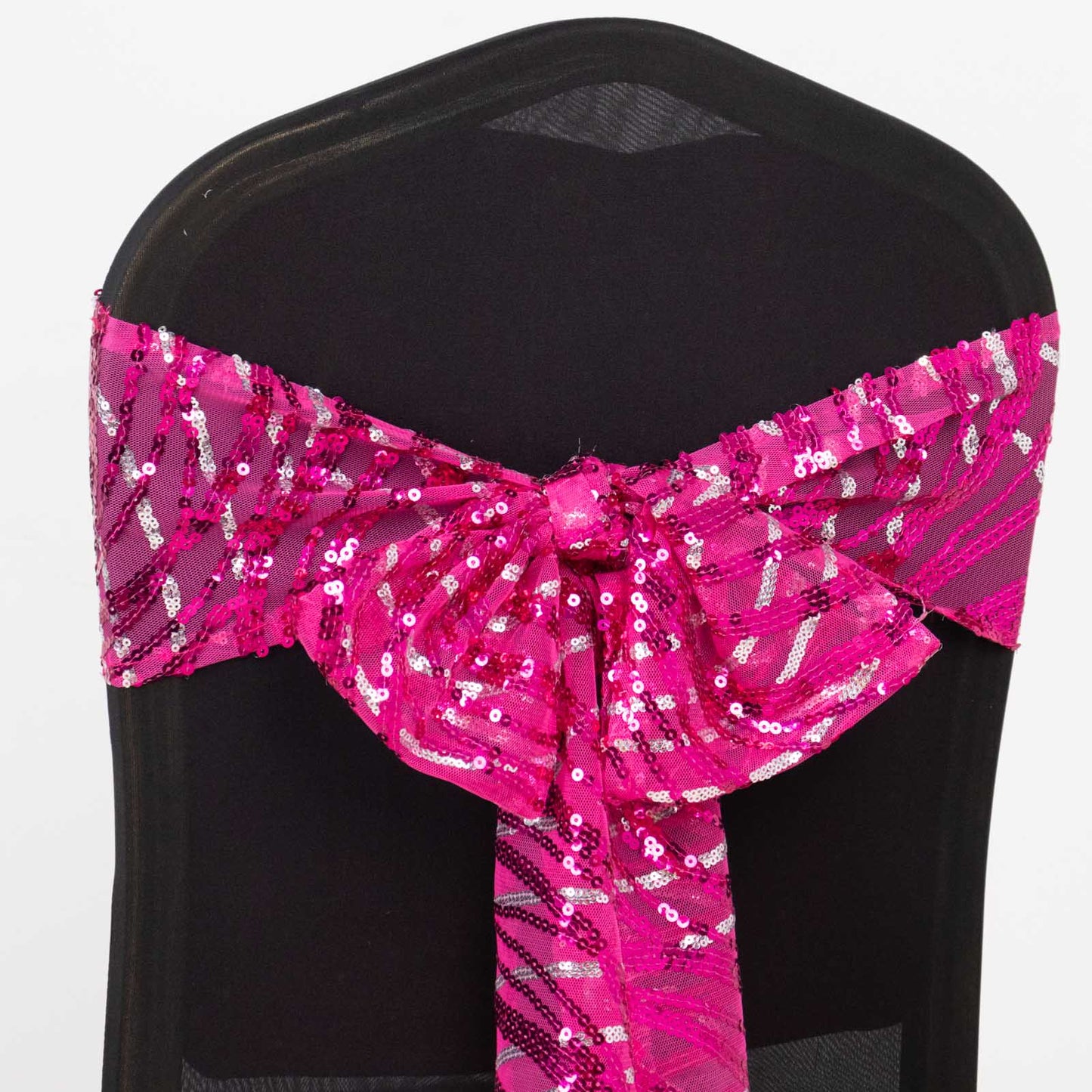 Fuchsia silver wave embroidered sequin chair sash on a black chair.