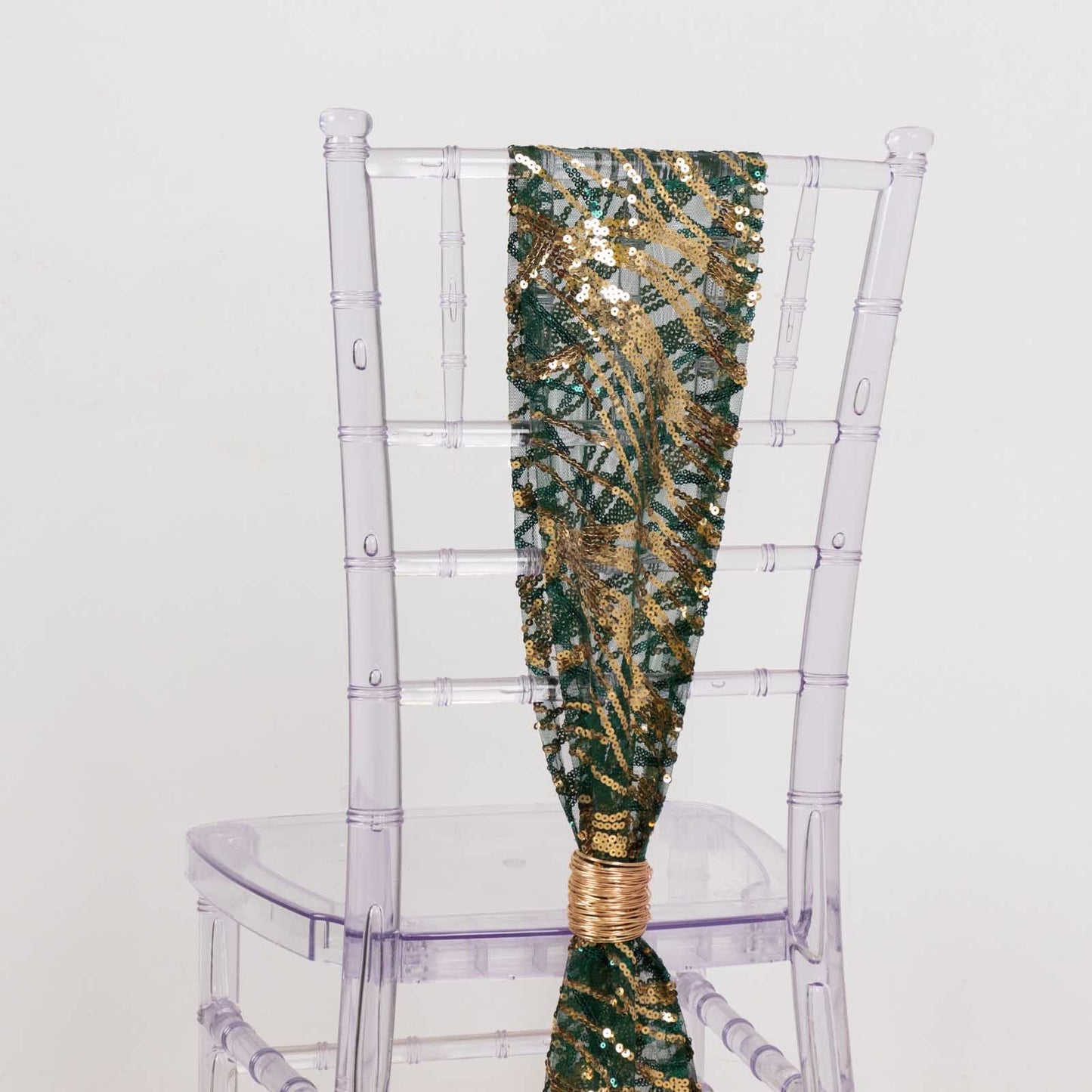 Hunter emerald green and gold wave embroidered sequin chair sash on a clear chair.