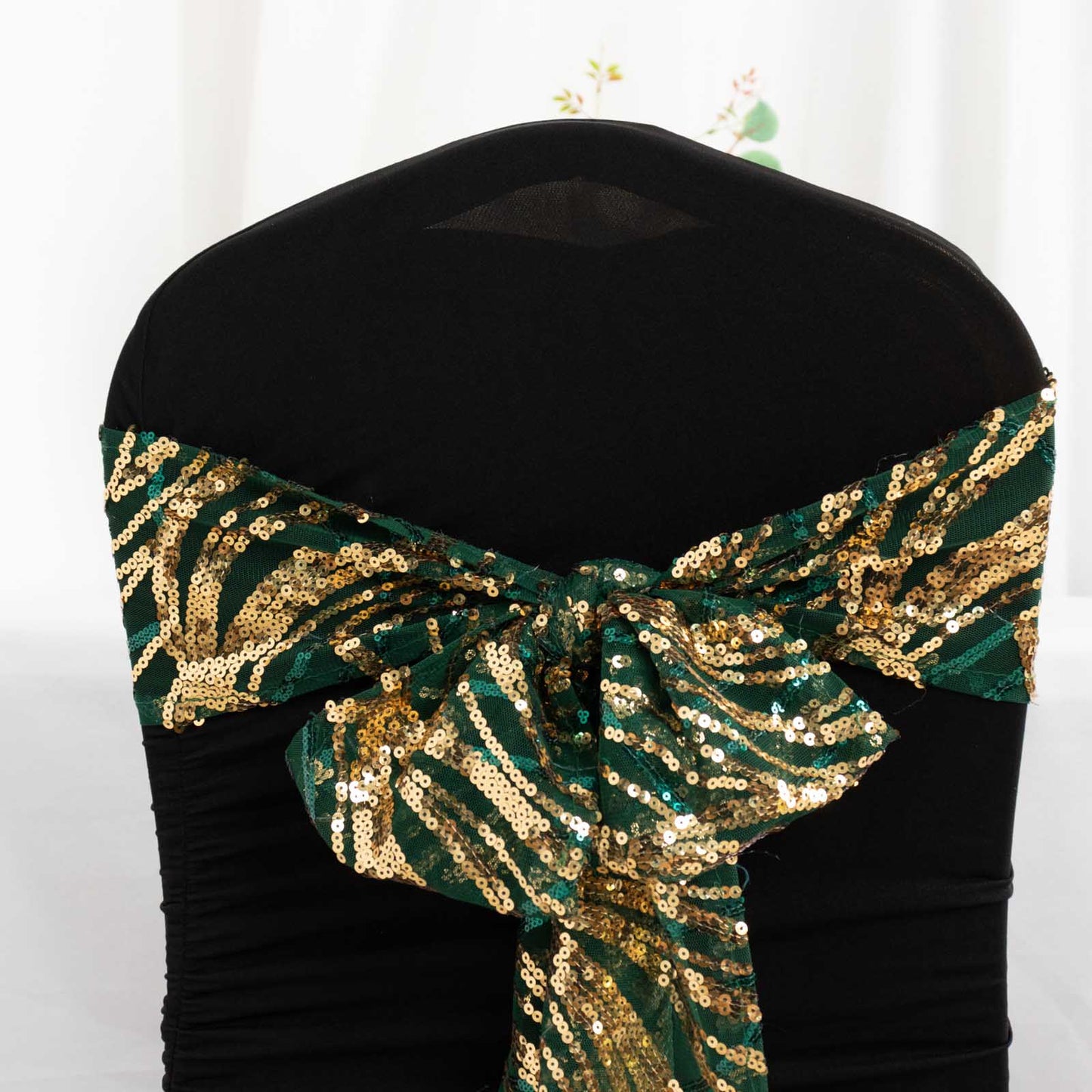 Hunter emerald green and gold wave sequin chair sash on a black chair.