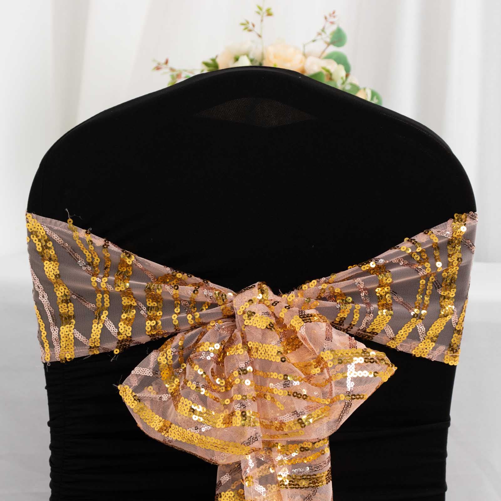 Rose gold mesh chair sash with gold wave sequins on a black chair.