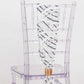 White and black wave embroidered sequin mesh chair sash on a transparent chair.