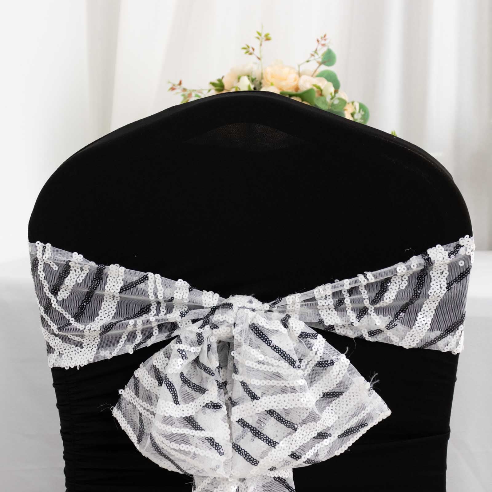 White and black wave embroidered sequin mesh chair sashes on a black chair.