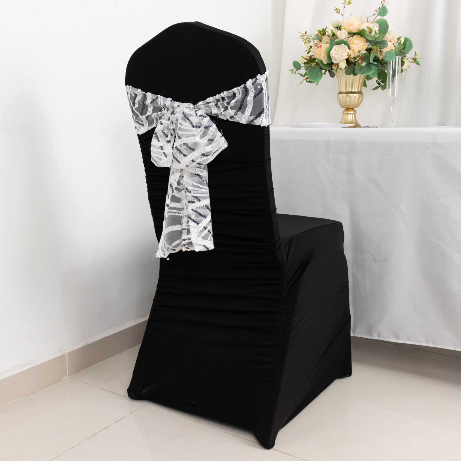 White and black wave embroidered sequin mesh chair sash on a black chair.