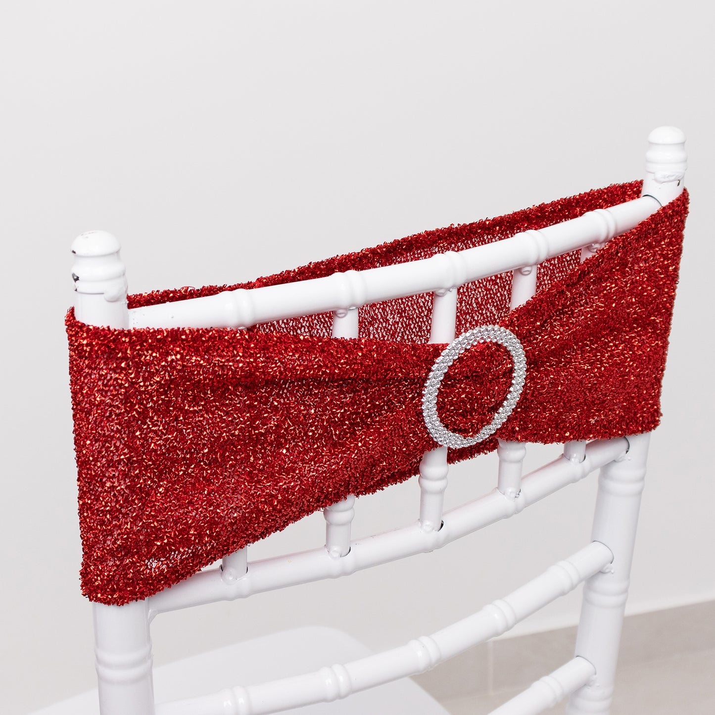 Red shimmer tinsel spandex stretch chair sash with silver rhinestone buckle.