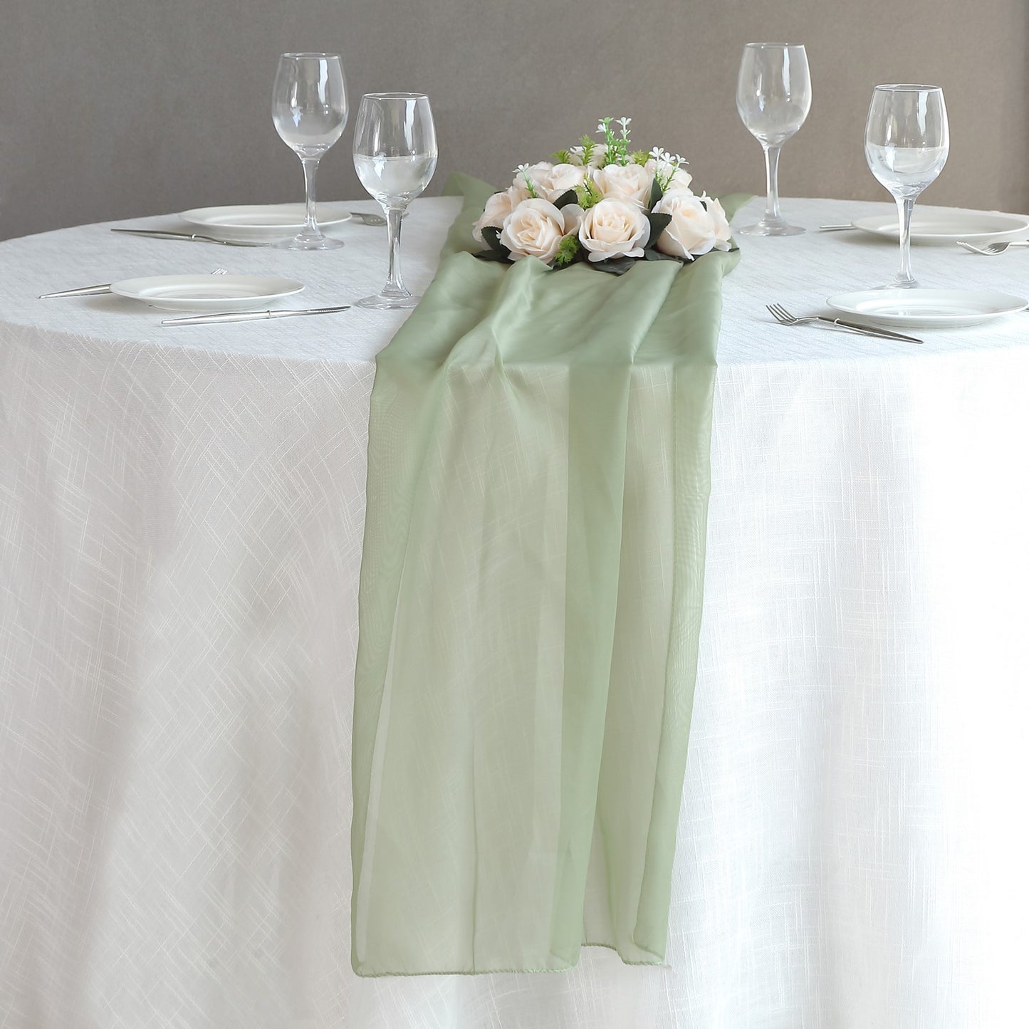 6ft Dusty Sage Green Chiffon Table Runner on a dining table with flowers.