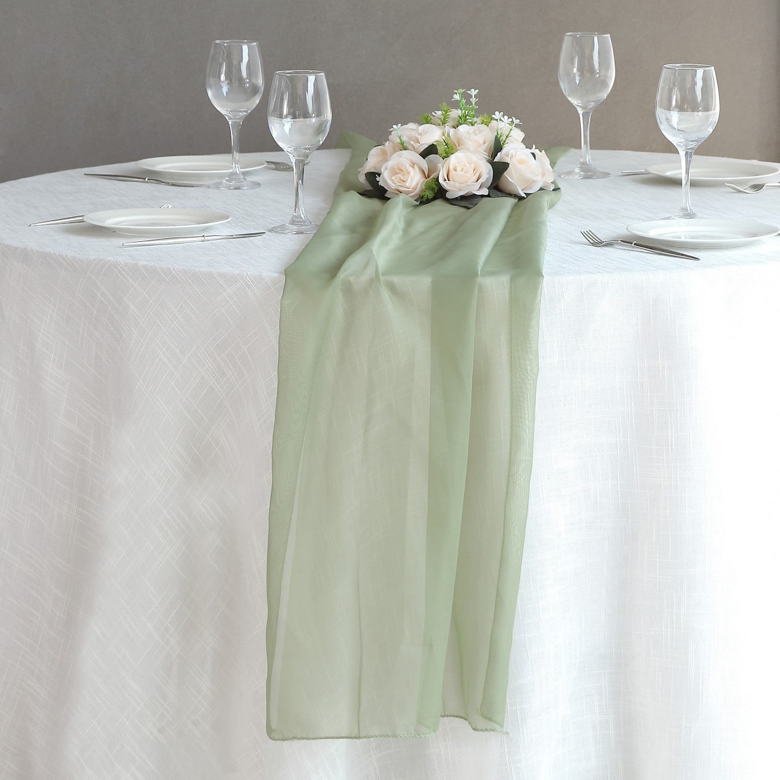 6ft Dusty Sage Green Chiffon Table Runner on a dining table with flowers.
