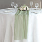6ft Dusty Sage Green Chiffon Table Runner on a dining table with floral decor.