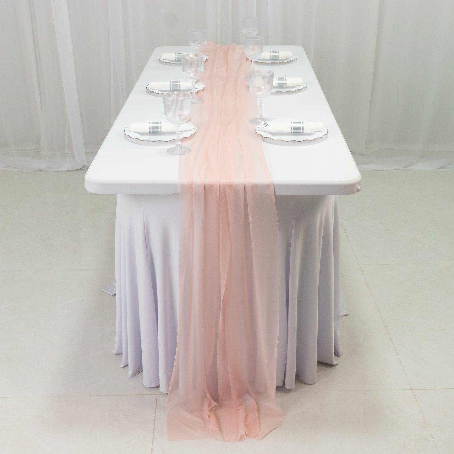 Blush sheer table runner draped on a white table setting.