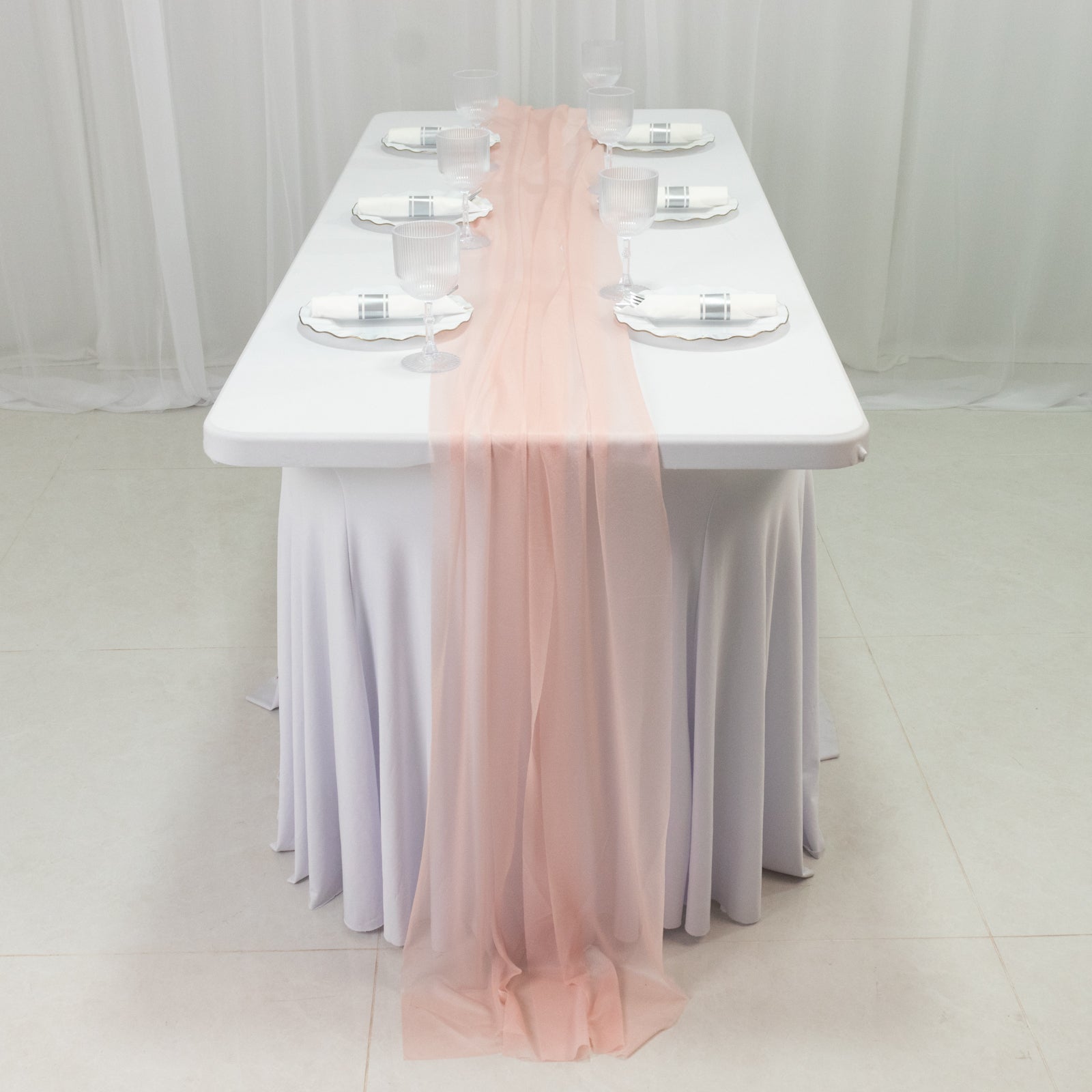 Blush sheer table runner draped on a white table setting.