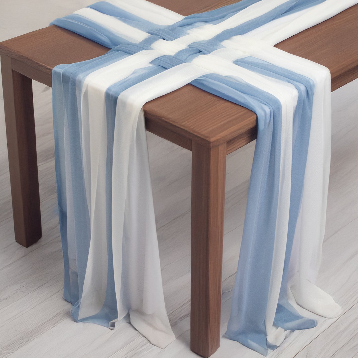 Dusty blue and ivory sheer table runners draped on a wooden table.