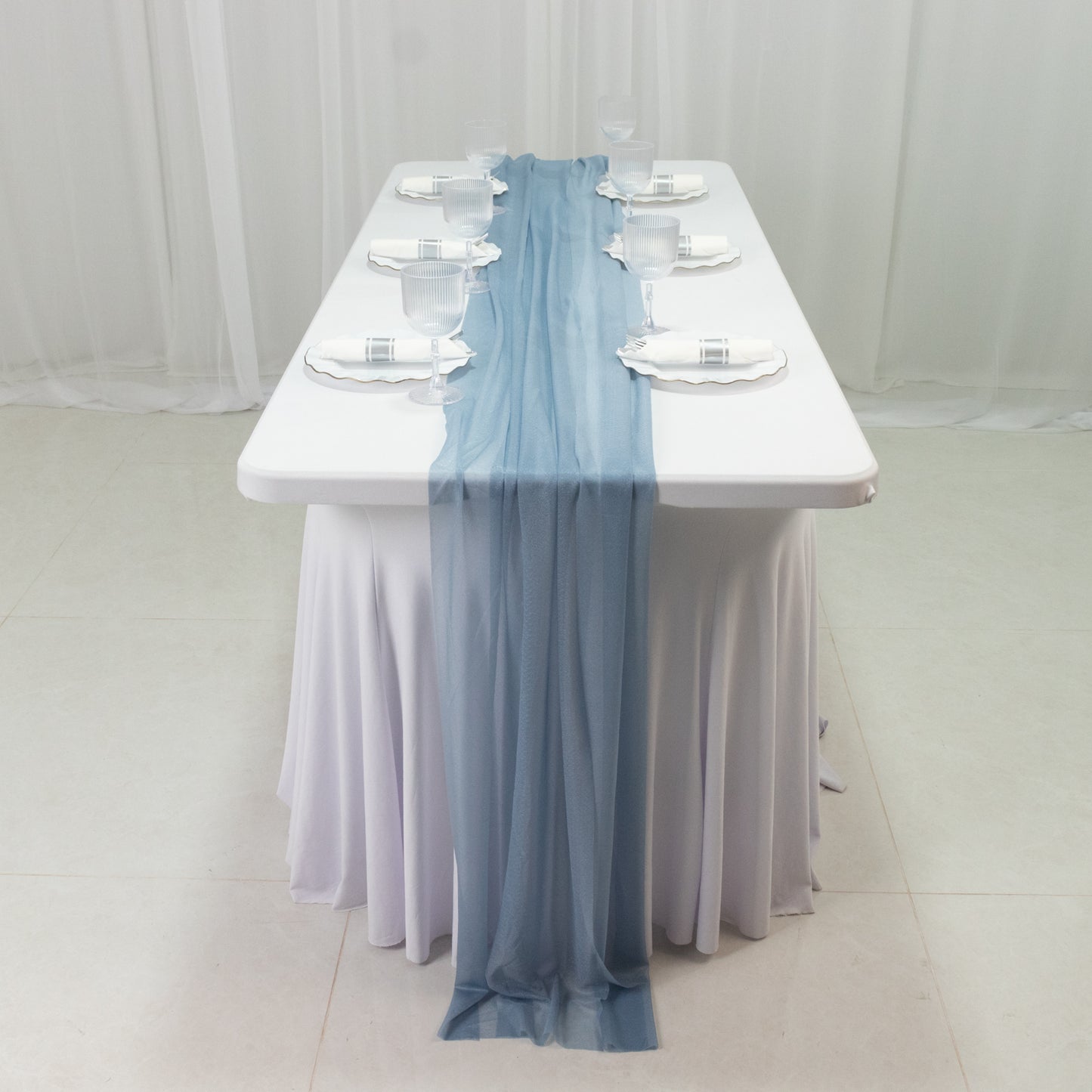 Dusty blue sheer table runner on a white table setting.