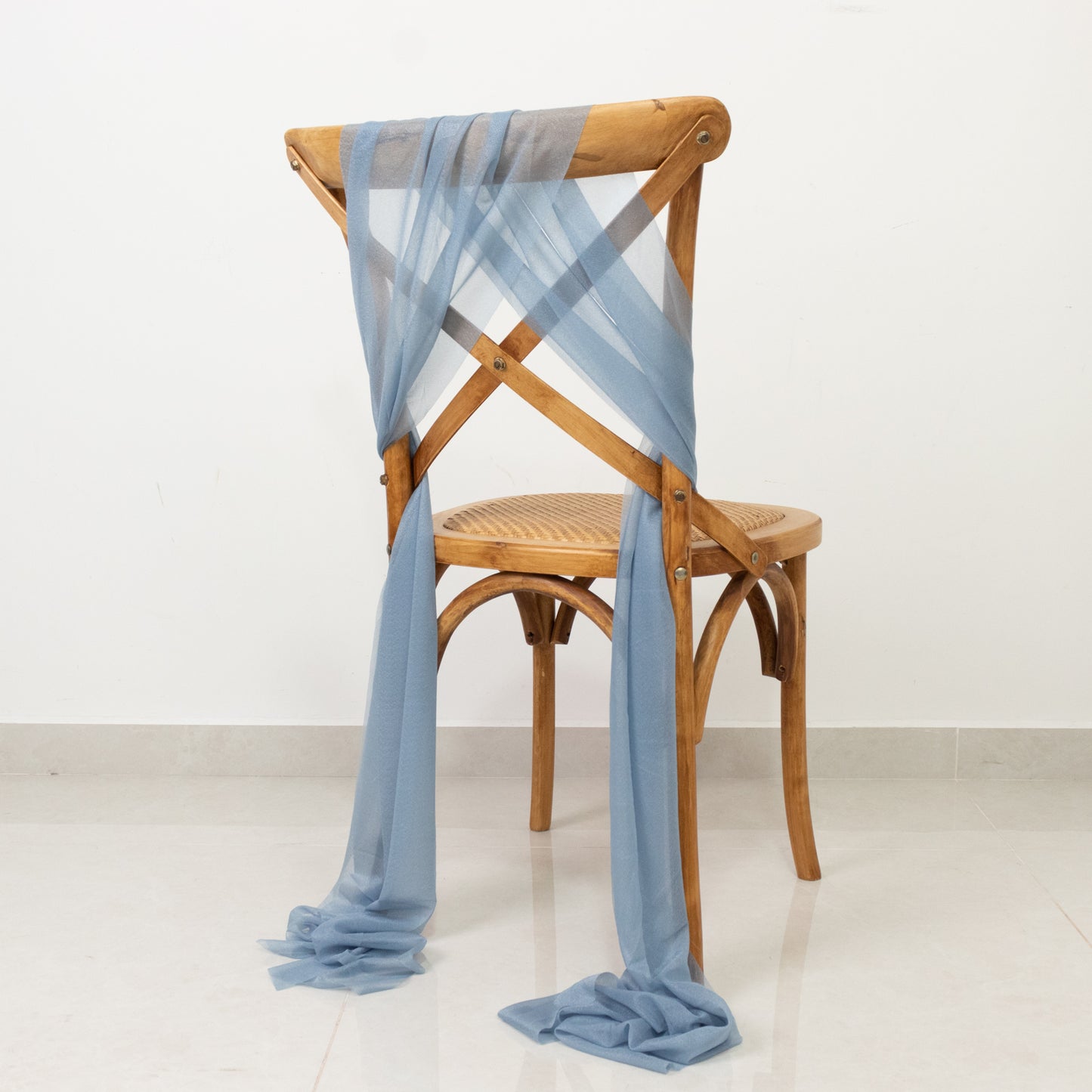 Dusty blue sheer chair drape decor on a wooden chair.