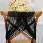 Black sheer chair drape with shimmer sash on wooden chair.
