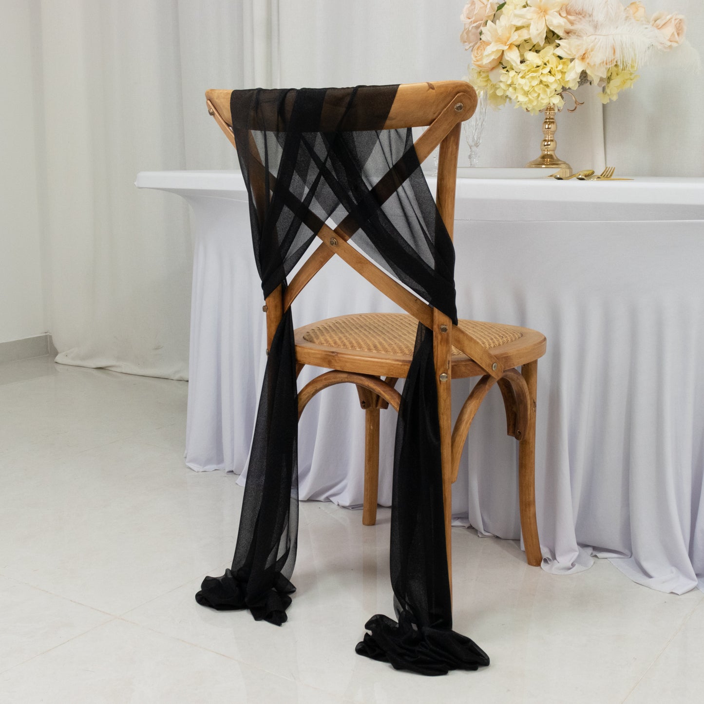 Black sheer chair drape decor with 9ft shimmer sash on a wooden chair.