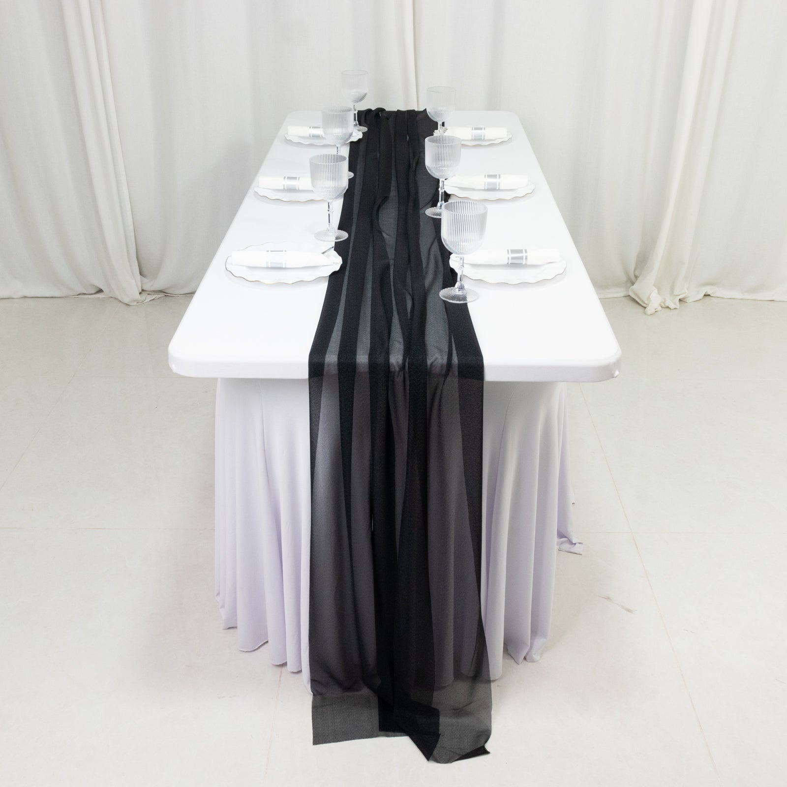 Black shimmer sheer table runners on a white table setting.