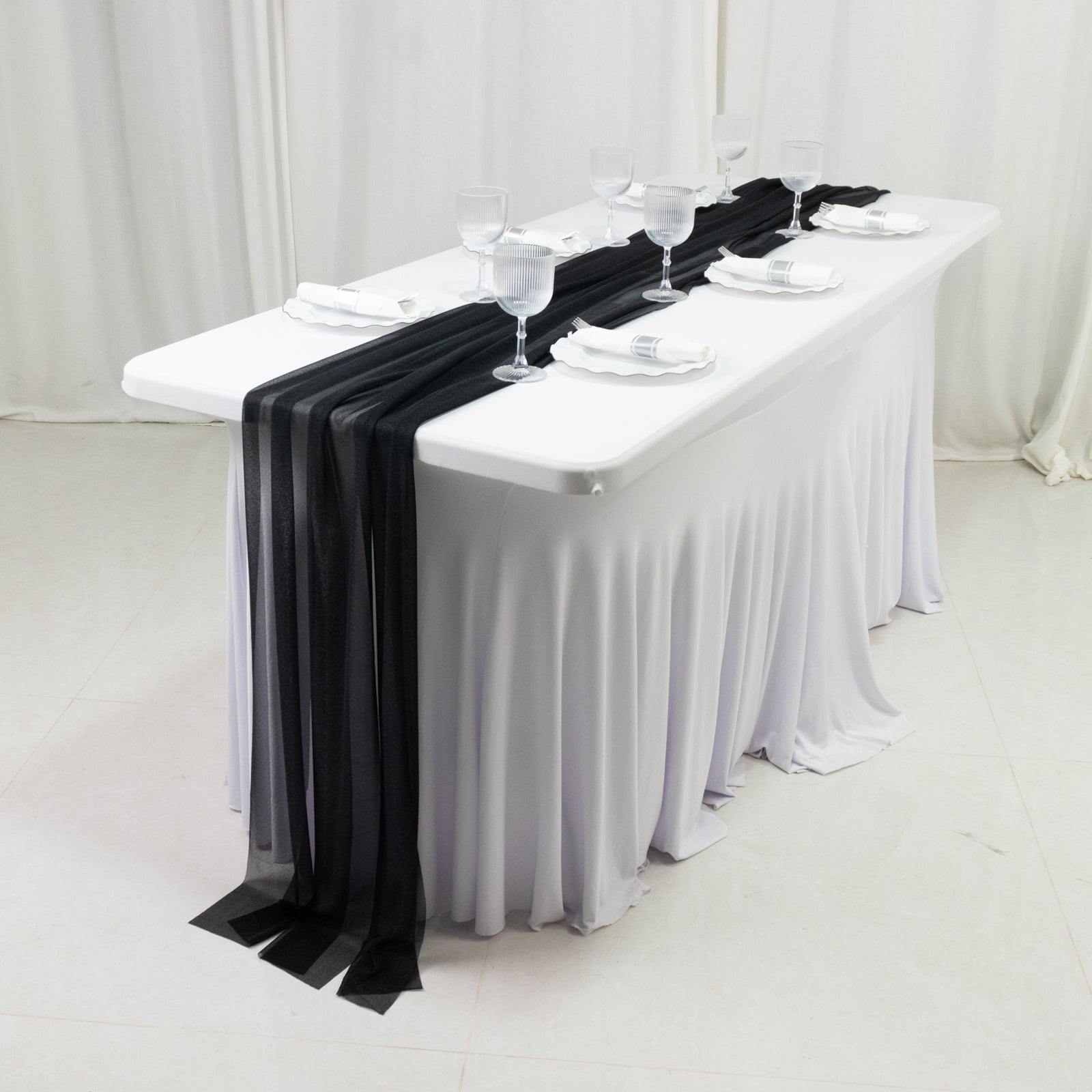 Black shimmer sheer table runners on a white table setting.