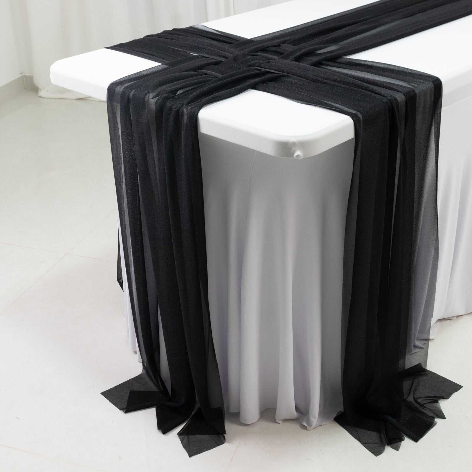 Black shimmer sheer table runners on a white table.