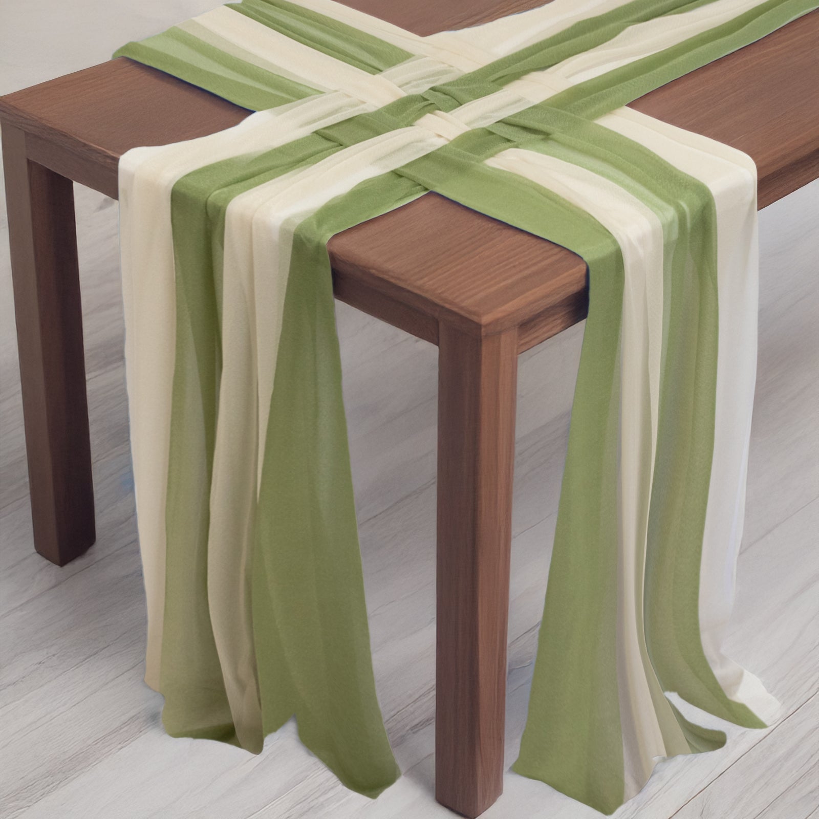 Dusty sage green and beige sheer table runners on a wooden table.