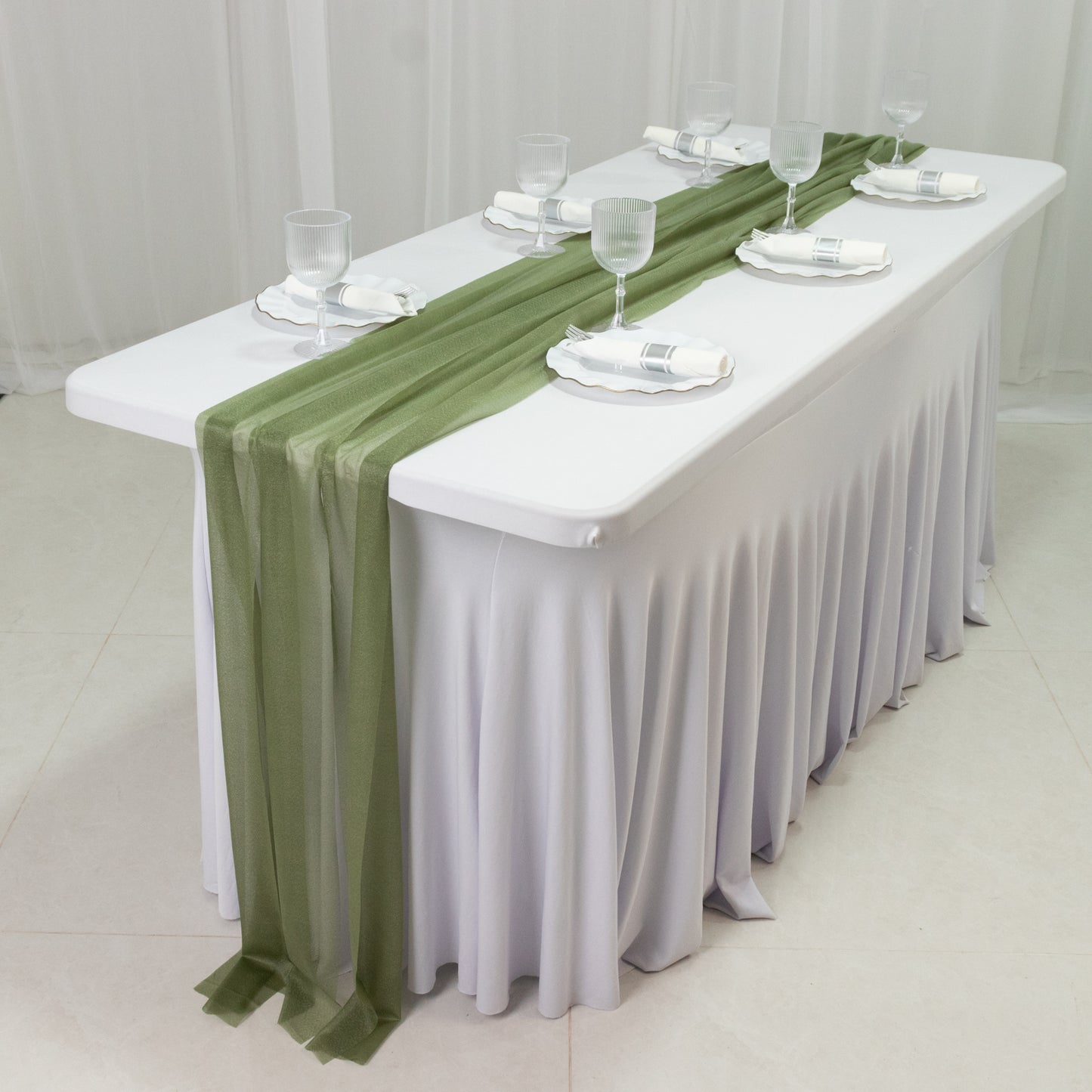 Dusty sage green sheer table runners draping a white table.