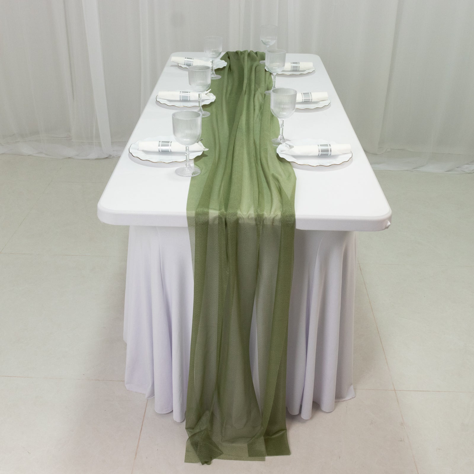 Dusty sage green sheer table runner on a white table setting.
