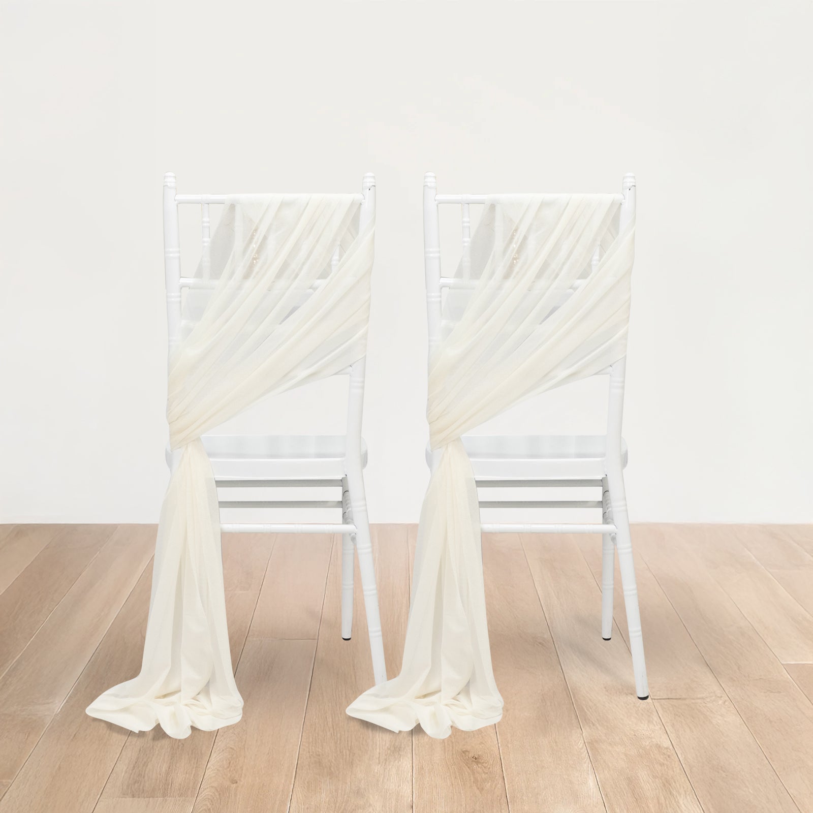 Ivory sheer chair drape decor with shimmer sash on white chairs.