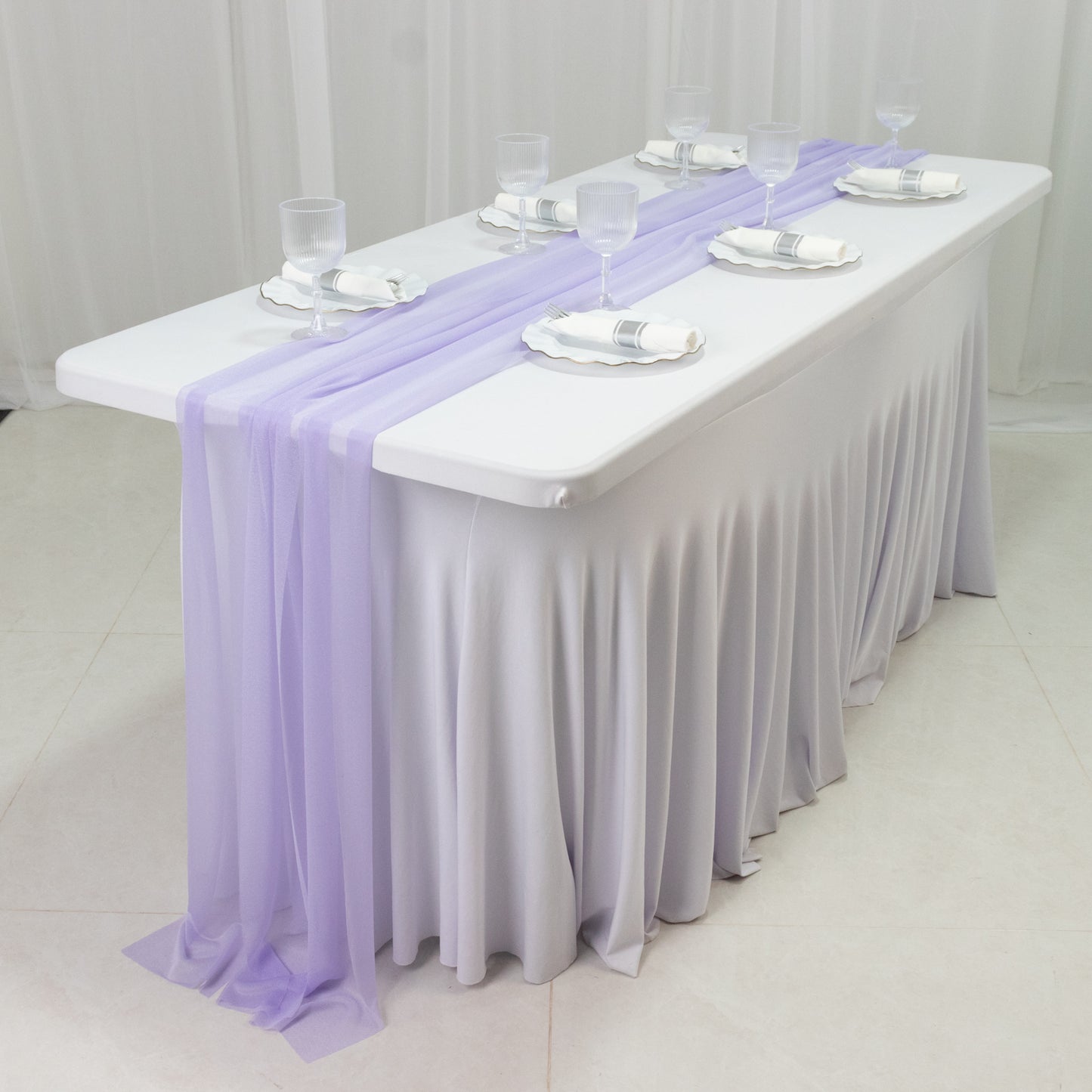 Lavender sheer table runners draping elegantly over a white table.