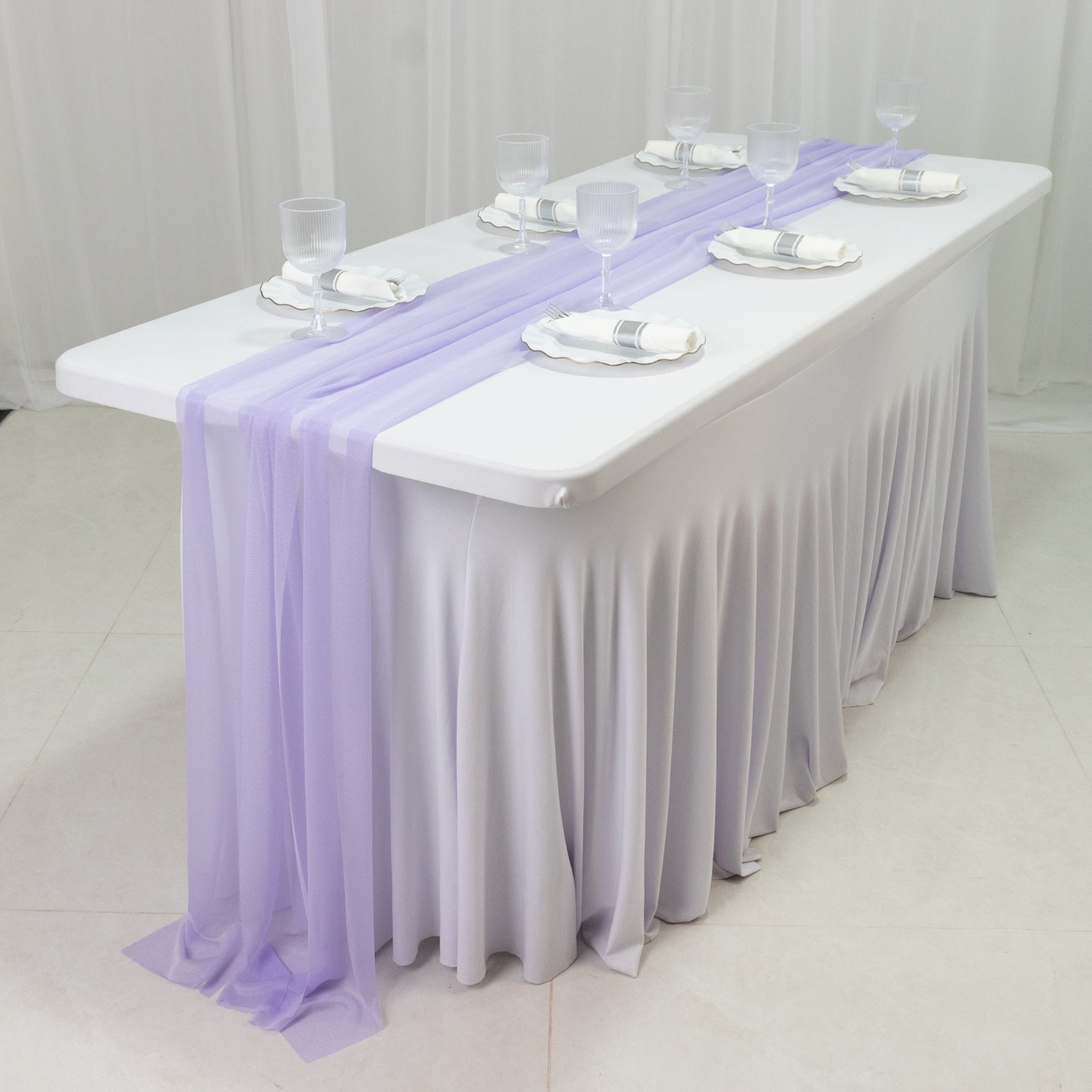 Lavender sheer table runners draping elegantly over a white table.