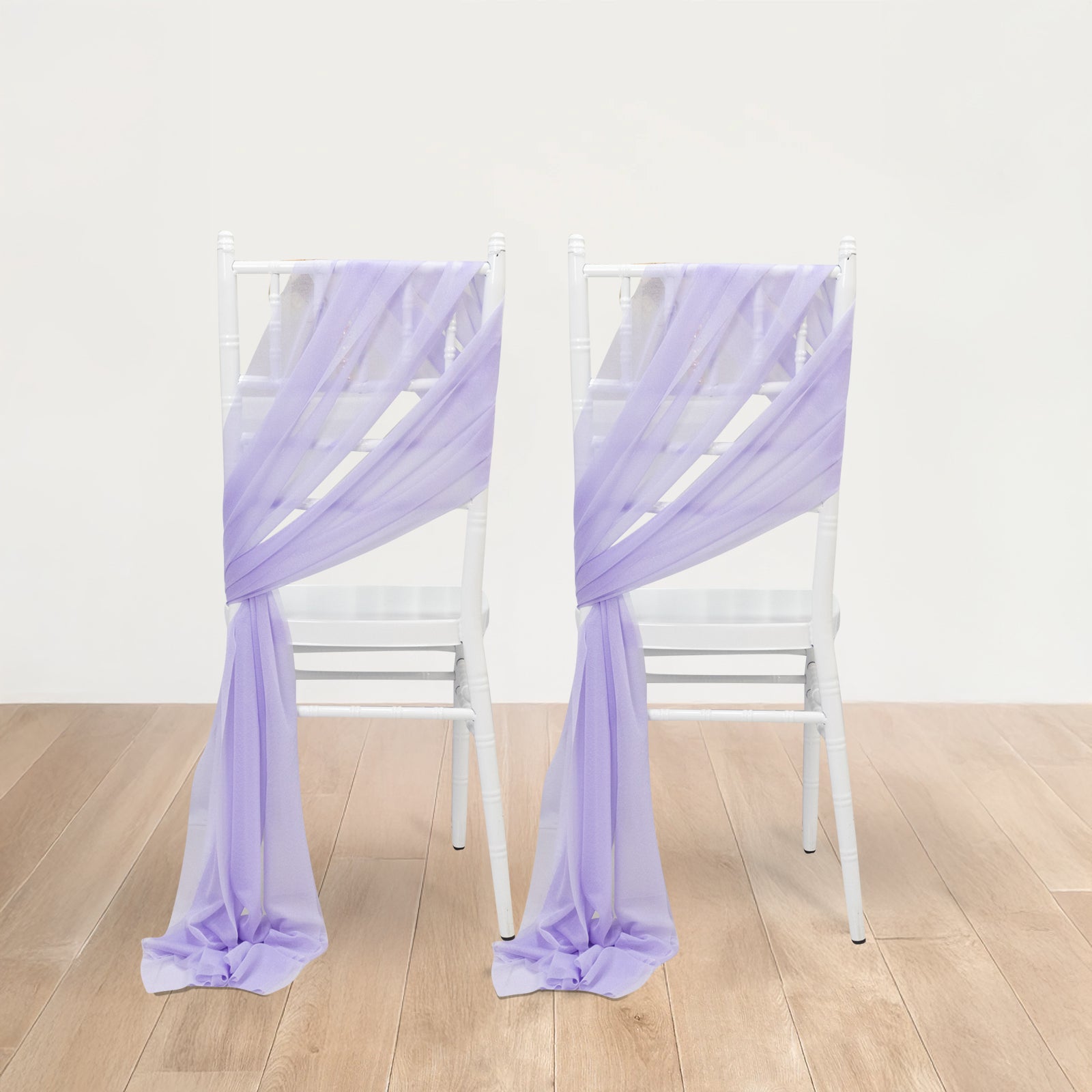 Lavender lilac sheer chair drape decor on white chairs.