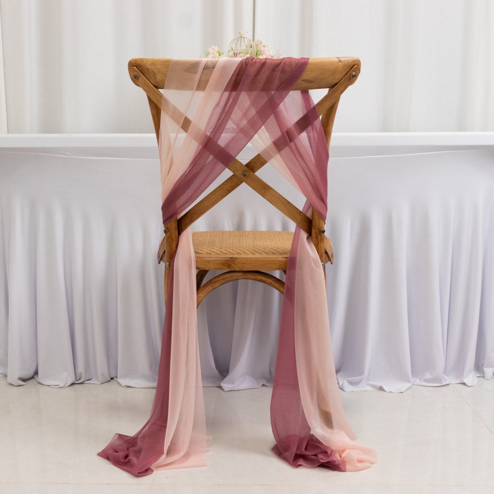 Mauve and blush sheer drape decor on a wooden chair.