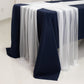 White sheer table runners draping over a navy blue table.
