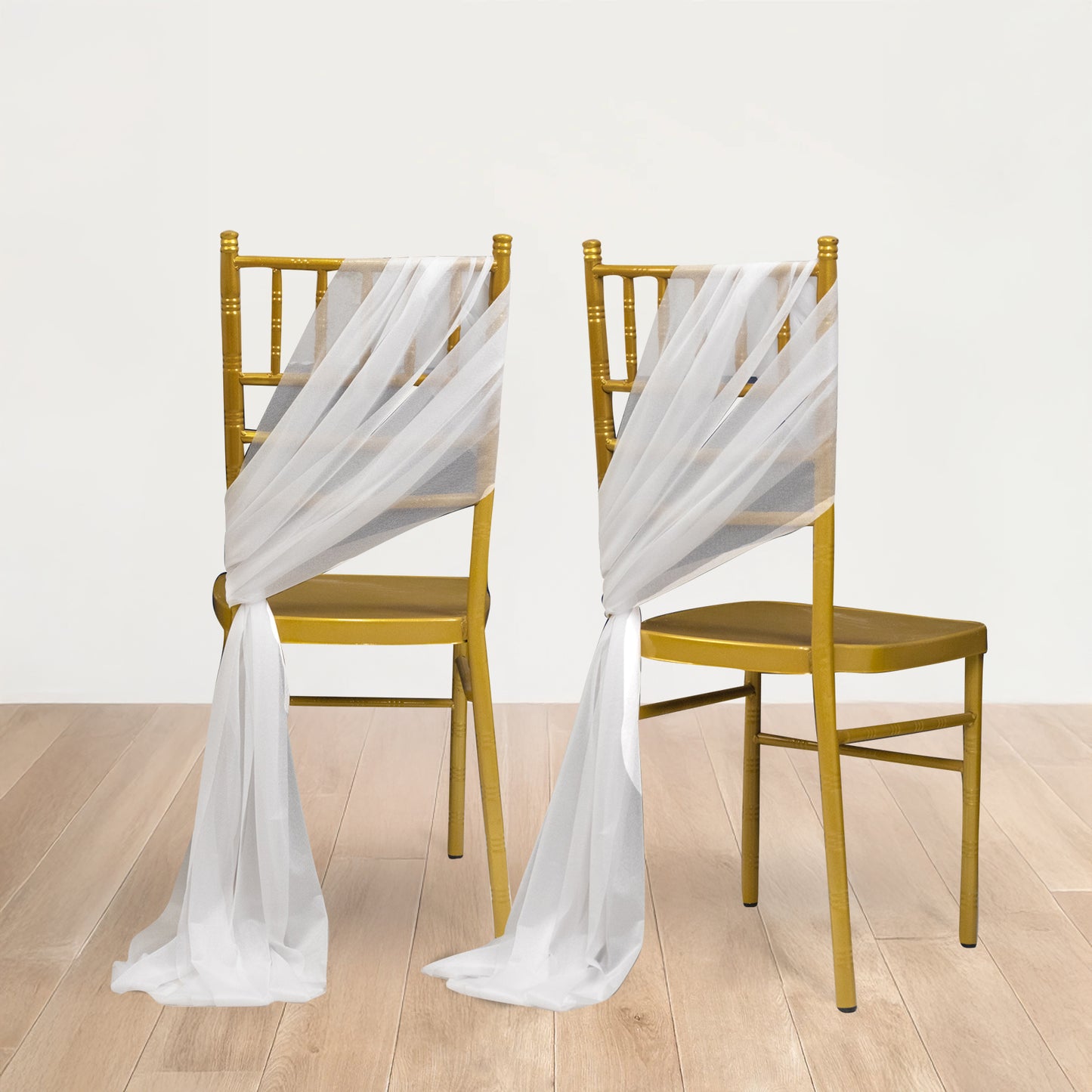 White sheer chair drape decor with shimmer sash on gold chairs.