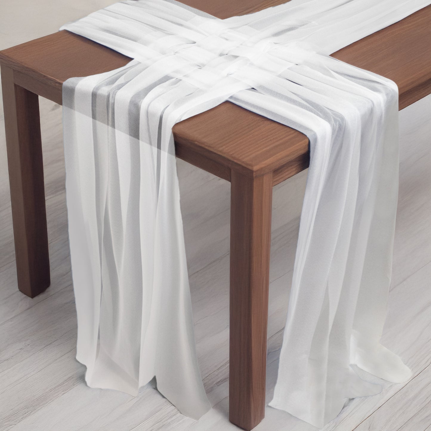 White shimmer sheer table runners draped over a wooden table.