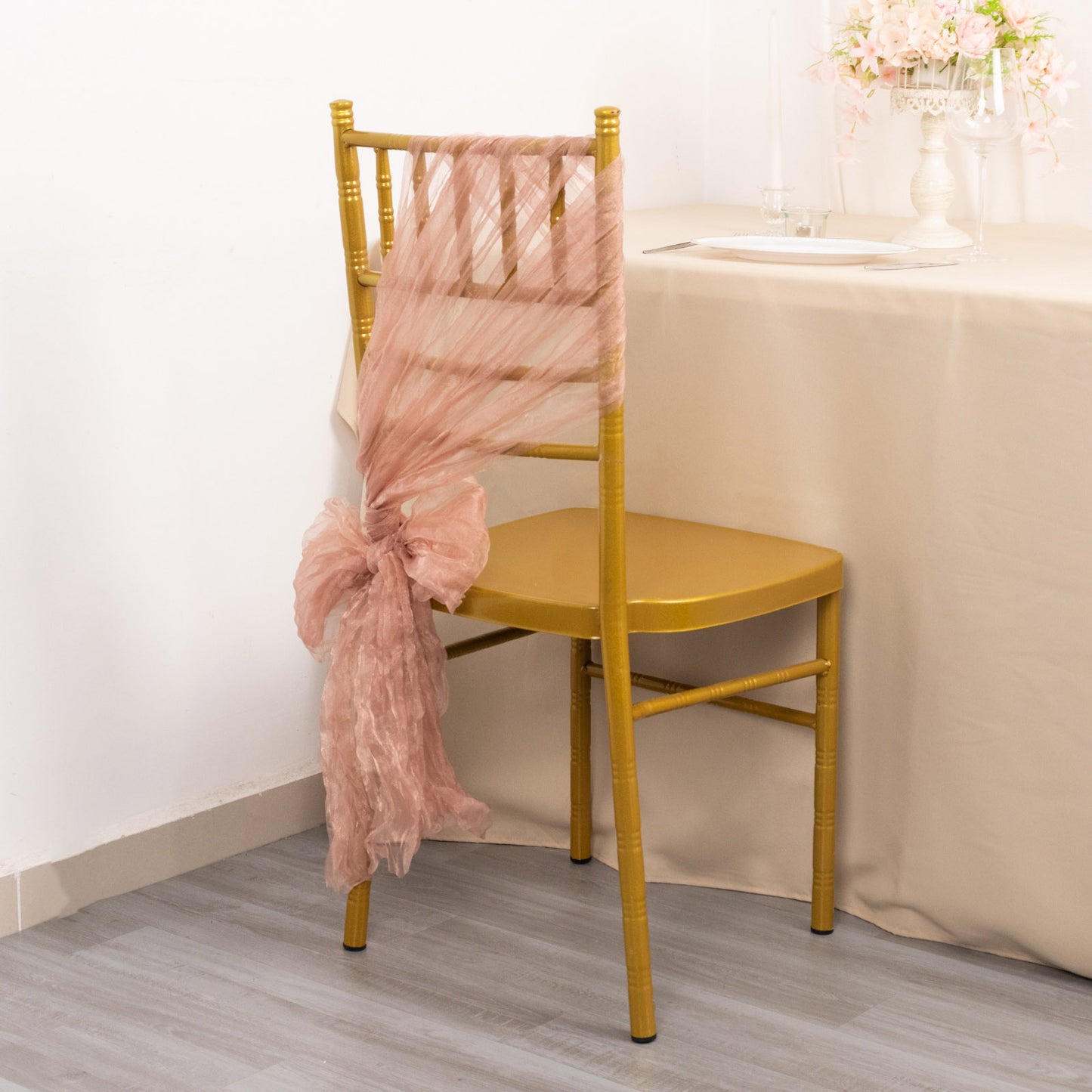Dusty rose sheer crinkled organza chair sash on a gold chair.